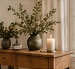 Budget-friendly wooden console styled with a leafy vase and ceramics